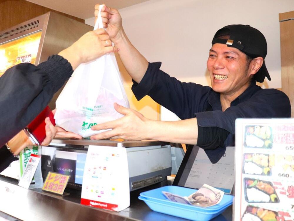 お客さまに商品をお渡ししている小川代表の写真/小川精肉店