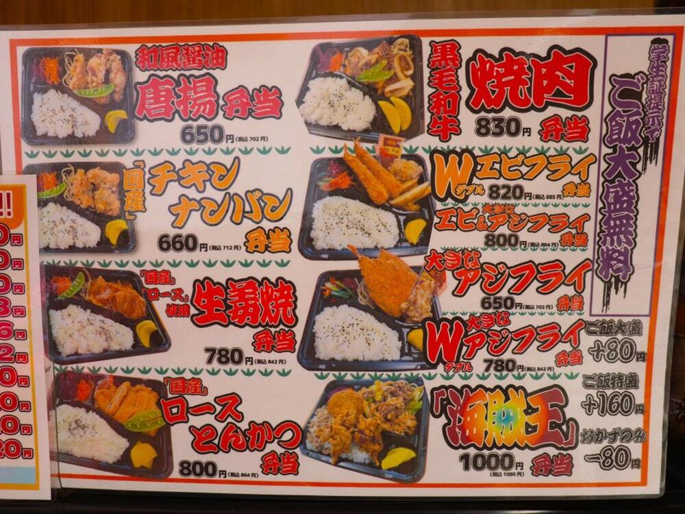 小川精肉店で提供されている各お弁当のメニュー表の写真/学生証提示でご飯大盛り無料。黒毛和牛-焼肉弁当(￥830)。Wエビフライ弁当(￥800)。大きなエビ＆アジフライ弁当(￥800)。大きなアジフライ弁当(￥650)。大きなWアジフライ弁当(￥780)。海賊王弁当(￥1,000)。和風醤油-唐揚げ弁当(￥650)。国産チキン南蛮弁当(￥660)。国産ロース使用-生姜焼き弁当(￥780)。国産ロースとんかつ弁当(￥800)/小川精肉店