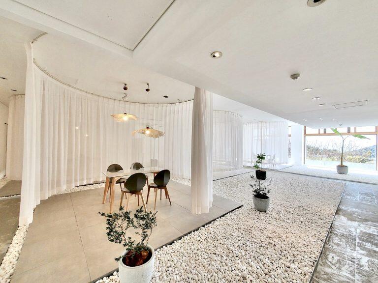 白いカーテンで丸く仕切られた各テーブル席は足摺岬の灯台を、床に敷き詰められた白い丸石は打ち寄せる白波をイメージ