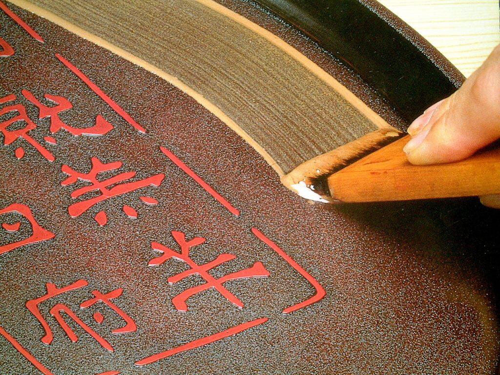 土佐古代塗は、まず栃などの木地に漆を厚く塗った後、クルミの殻を粉末にしたものでザラ地模様をつけます