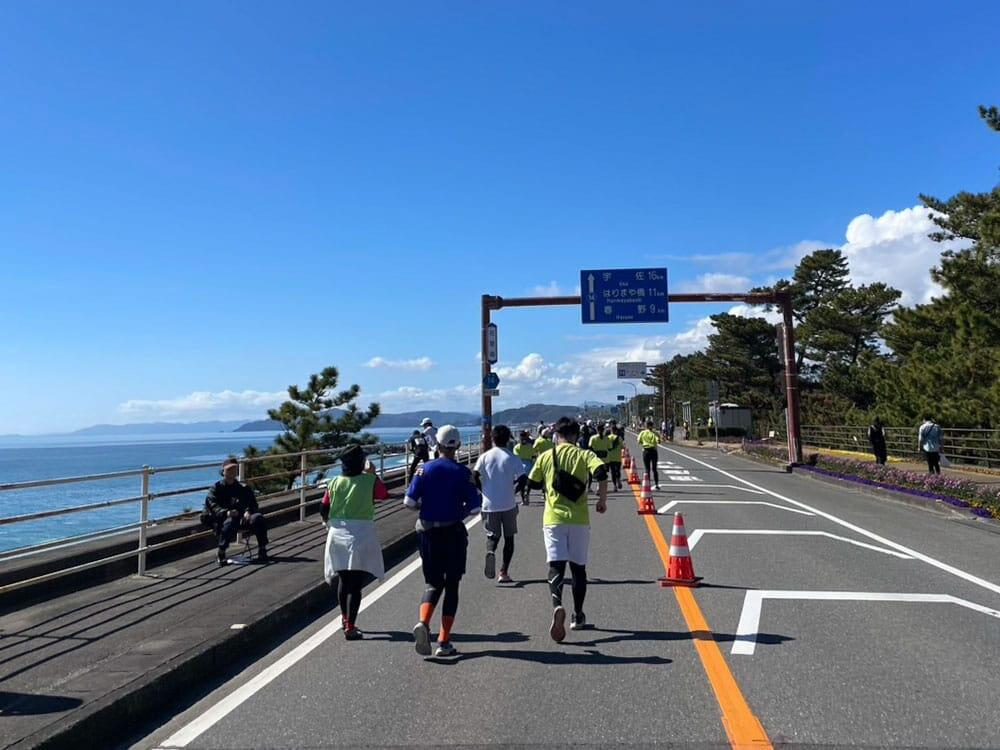 花街道から見える太平洋を眺めながら走るマラソン選手の様子②/高知龍馬マラソン